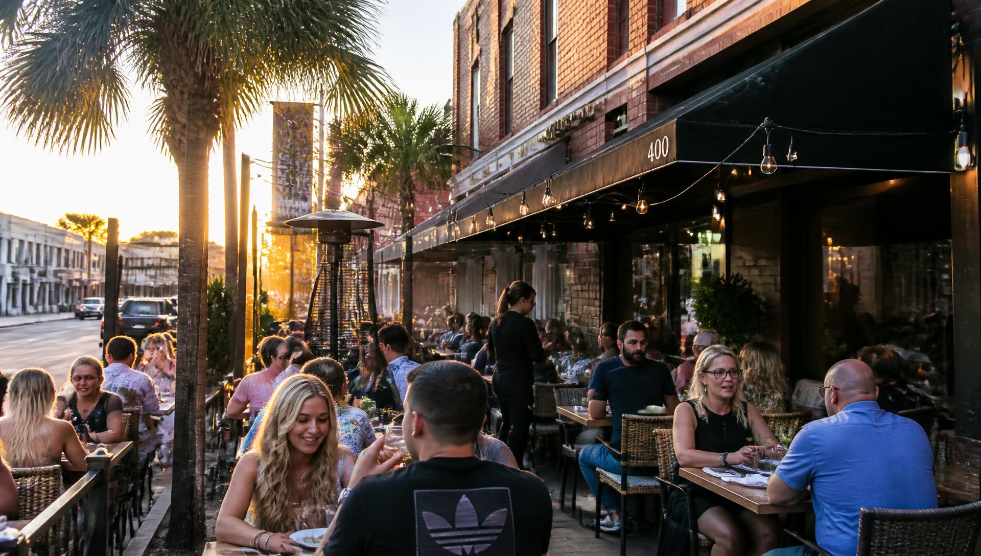 Diners on a restaurant patio in downtown St. Petersburg at golden hour
